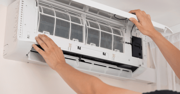 A hand of technician is doing a air conditioner maintenance.