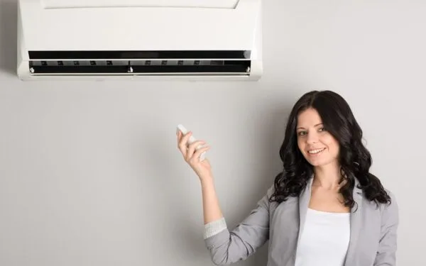 The woman is standing under Fujitsu split air conditioner.