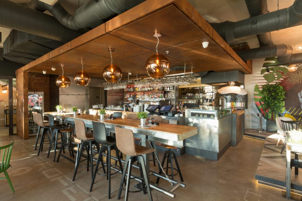 Modern restaurant interior with visible ducted air conditioning system, showcasing effective AC for restaurant comfort.