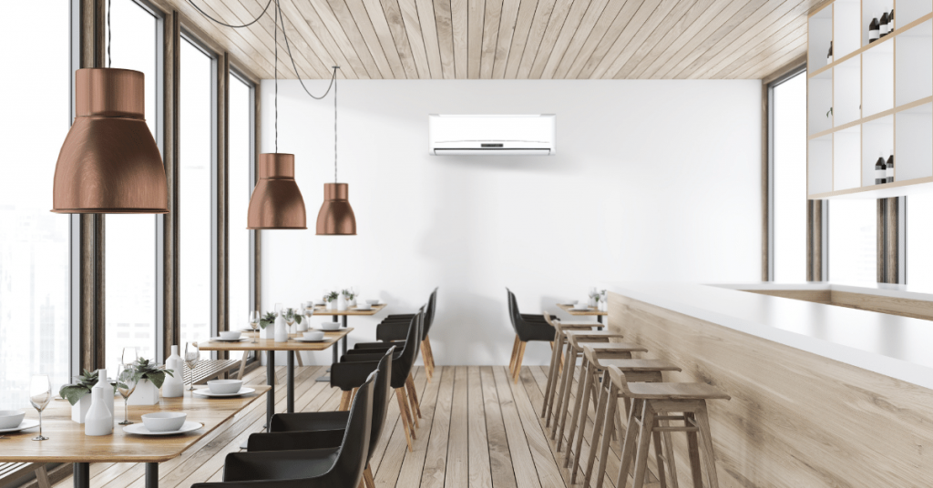 Bright minimalist restaurant featuring a wall-mounted split system unit, ideal AC for restaurant cooling.