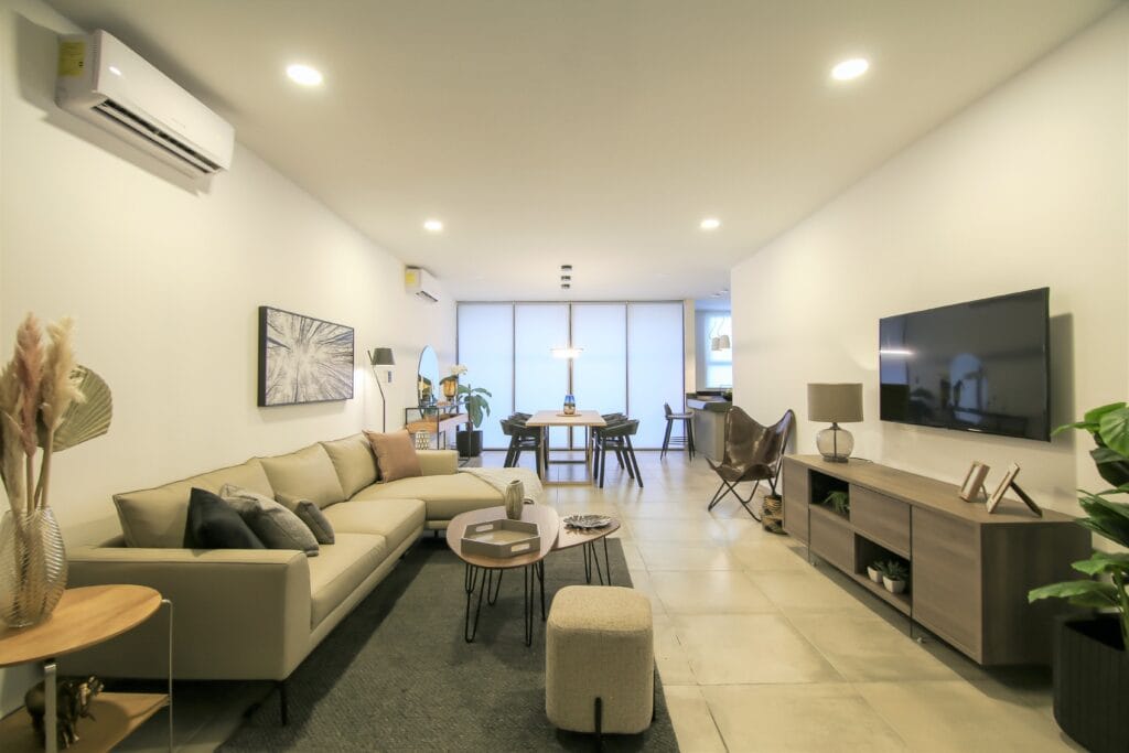 Spacious hotel suite with two wall-mounted air conditioning units, demonstrating the benefits of AC in hotel rooms for full-area cooling and guest relaxation.