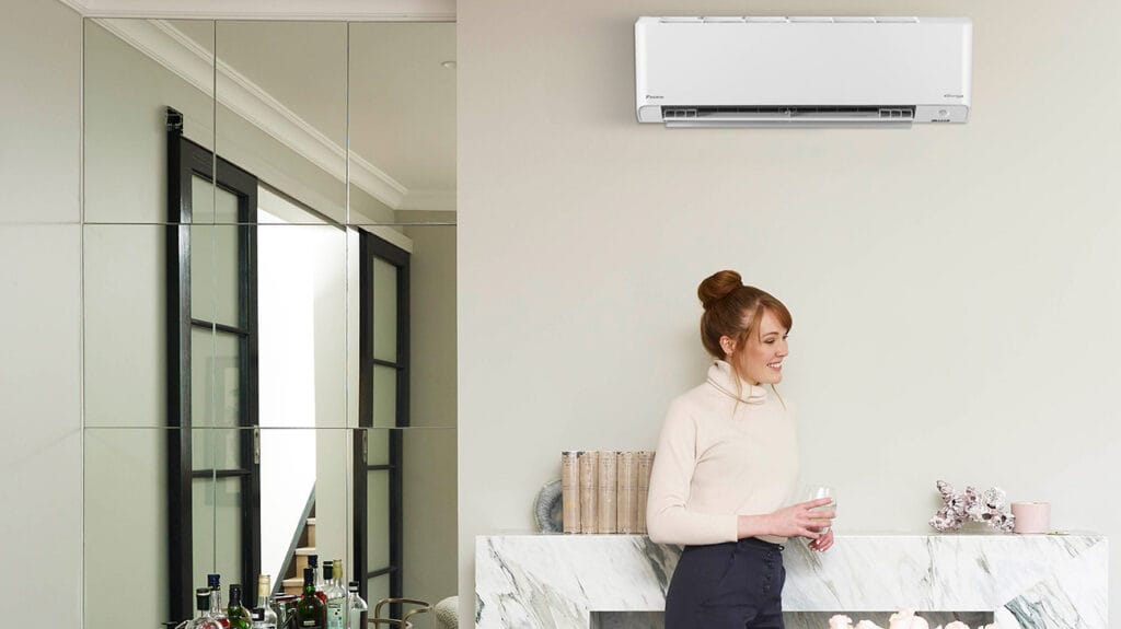 The woman is standing under the Daikin air conditioners 2025