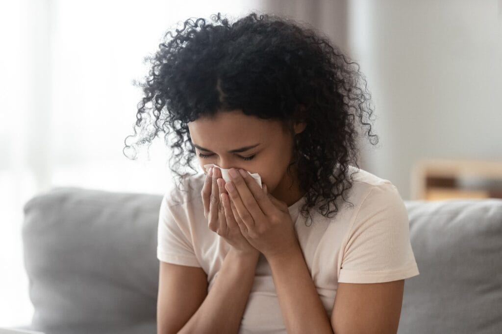 Young woman experiencing air conditioner lung symptoms, air conditioning Gold Coast.