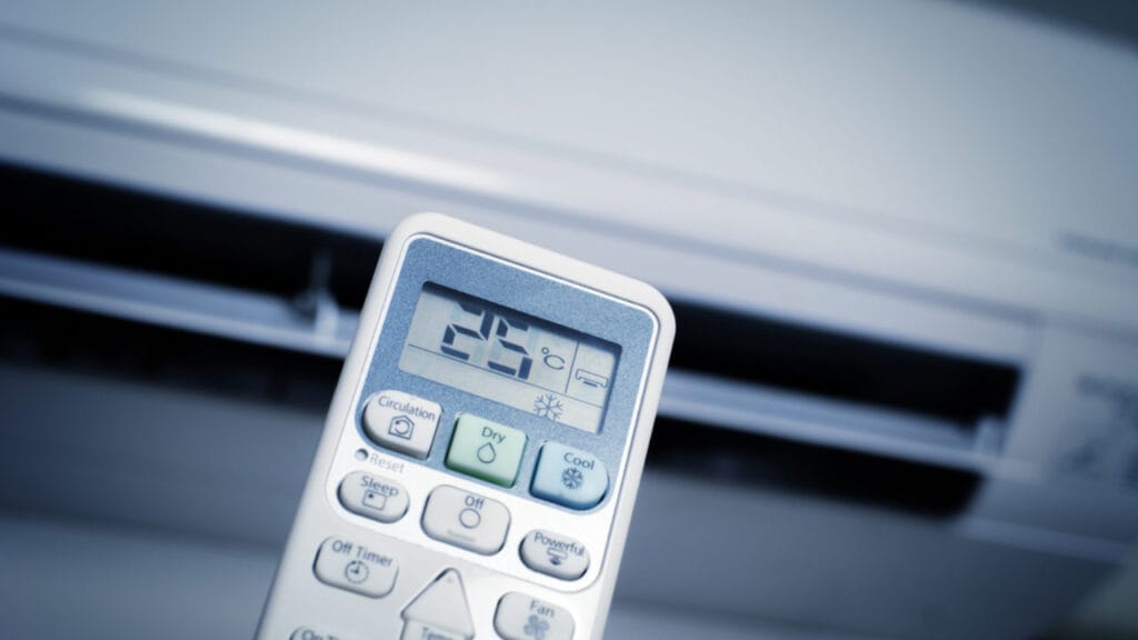 Close-up of an air conditioner remote set to 25°C with DRY and COOL modes visible, highlighting hidden features in your AC remote.