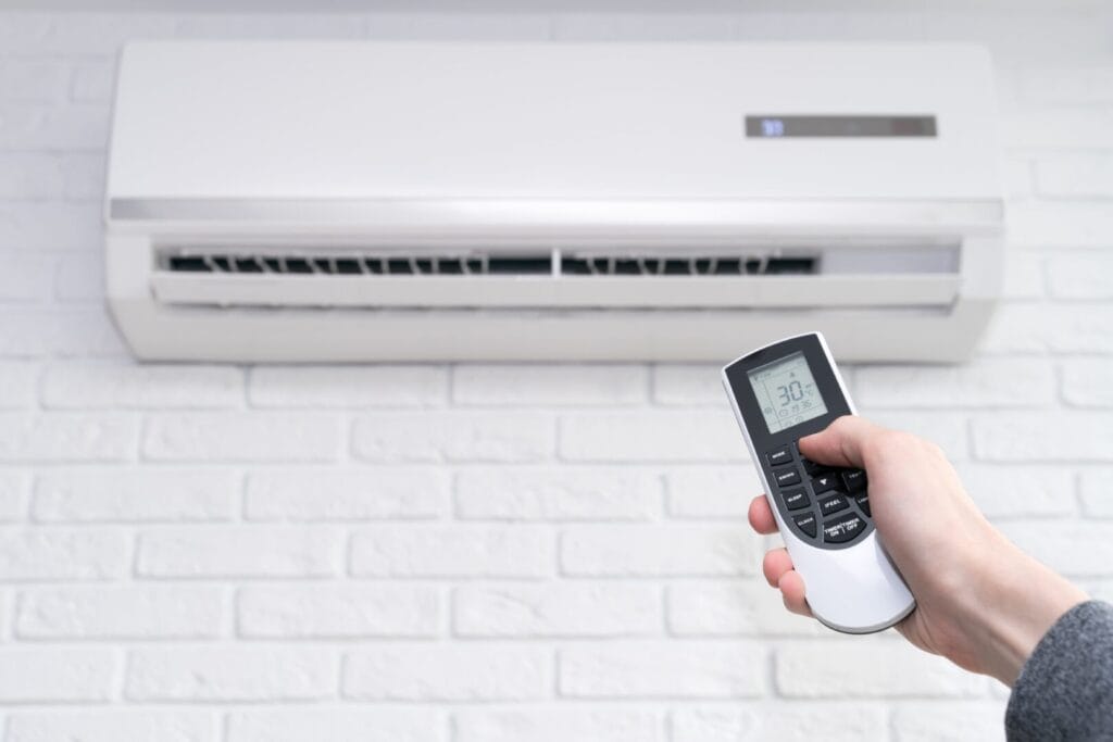 Air conditioner set to 30°C with a modern remote displaying detailed settings, illustrating hidden features in your AC remote.