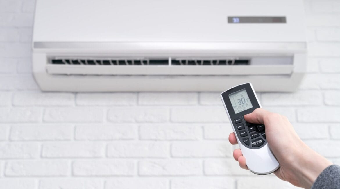 Air conditioner set to 30°C with a modern remote displaying detailed settings, illustrating hidden features in your AC remote.