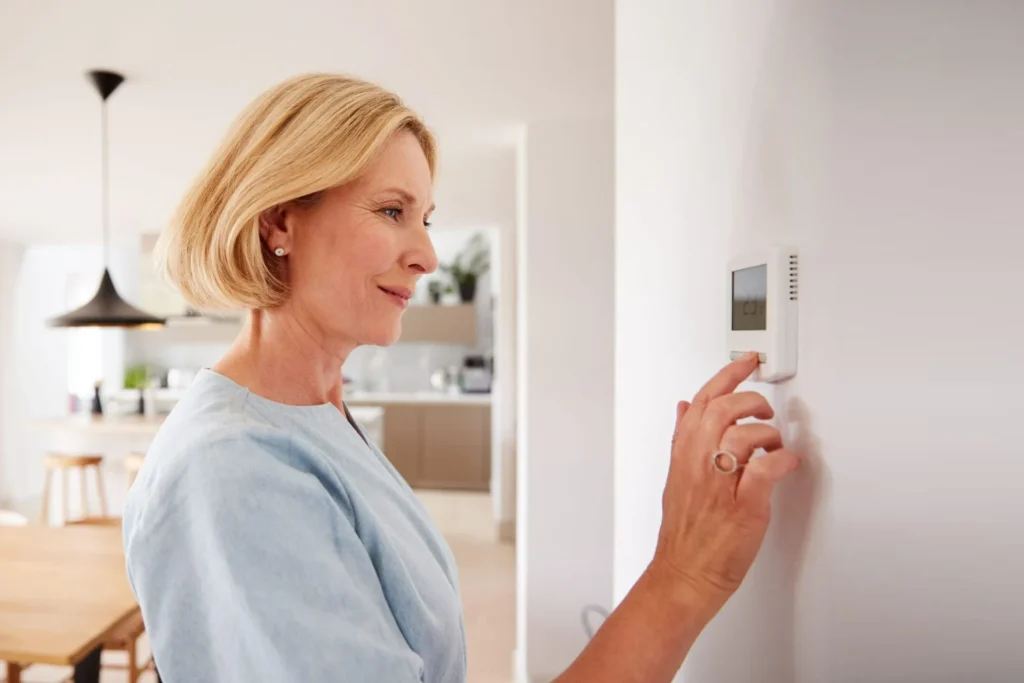 The woman is finding how to turn on the heating mode.