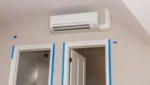 One air conditioner cools two rooms, with the unit installed above adjacent door frames, highlighting an efficient cooling layout.