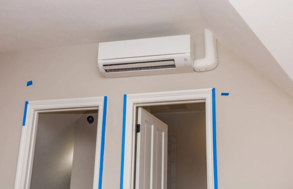 One air conditioner cools two rooms, with the unit installed above adjacent door frames, highlighting an efficient cooling layout.
