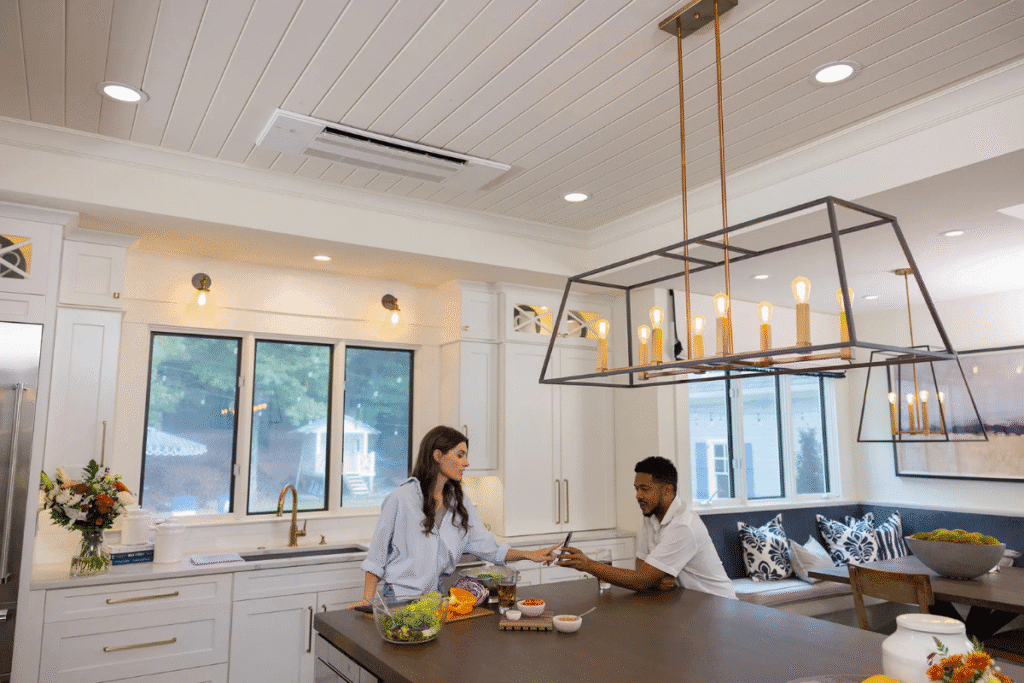 A stylish modern kitchen featuring a cassette air conditioner installed in the ceiling, offering discreet and efficient cooling—ideal for comparing cassette vs floor-standing air conditioners in DEEPCHILL's expert review on air conditioning Gold Coast.
