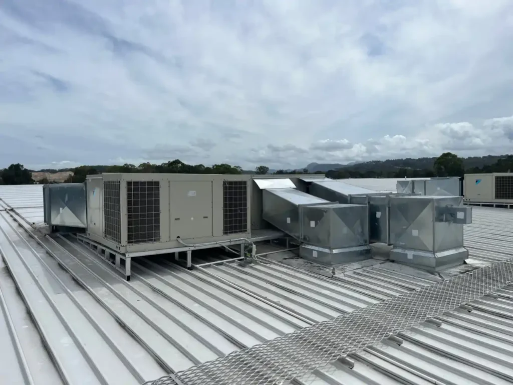 Large rooftop HVAC system with ductwork installed by DEEPCHILL on a commercial metal roof