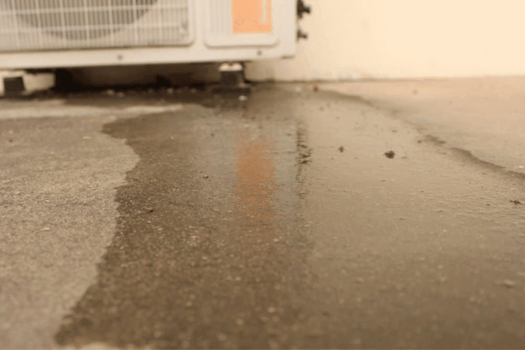 Close-up of puddle forming under AC outdoor unit – signs that the air conditioning unit leaks water in humid Gold Coast conditions.