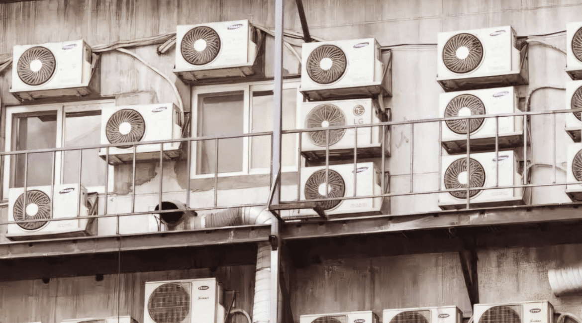 Cluster of multiple split system outdoor units on an apartment building, highlighting limitations compared to VRF systems – DEEPCHILL review on air conditioning Gold Coast.