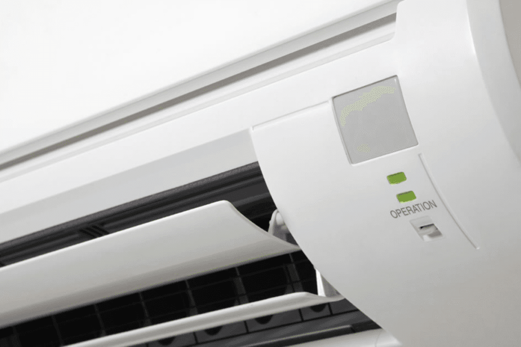 Close-up of an indoor AC unit with the green aircon light blinking during operation.
