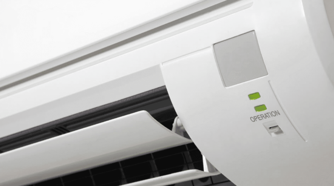 Close-up of an indoor AC unit with the green aircon light blinking during operation.