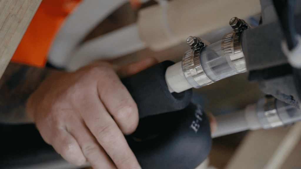 Close-up of a technician’s hand insulating pipes during aircon servicing, ensuring efficient thermal performance.