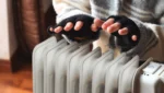 Hands warming up over an electric heater, showing heating mistakes like relying on inefficient portable units.