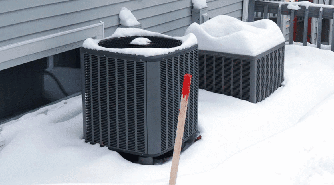 Snow-covered outdoor air conditioning units next to a house, highlighting the importance of proper maintenance when you use an air conditioner in the winter—essential air conditioning tips and tricks for homeowners in regions like the Gold Coast.