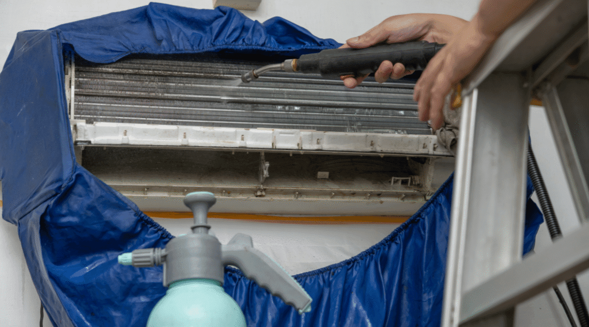 Technician performing Hydro Clean on split air conditioner coils using pressure spray. Professional cleaning service Gold Coast ensuring healthy indoor air.