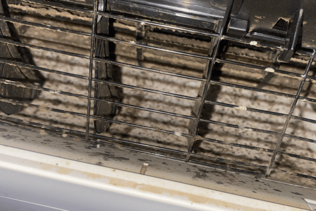 Dirty and mouldy air conditioning vents showing black buildup. 
