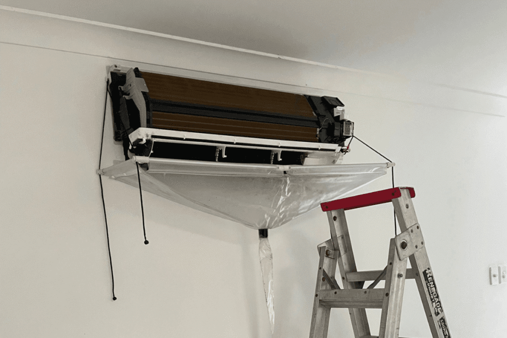 Air conditioner being cleaned with protective bag setup during Hydro Clean procedure. 