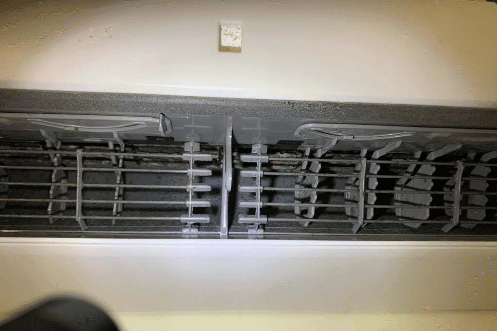 Close-up of dirty air conditioner vents before Hydro Clean, highlighting the need for regular aircon cleaning service to maintain healthy airflow.