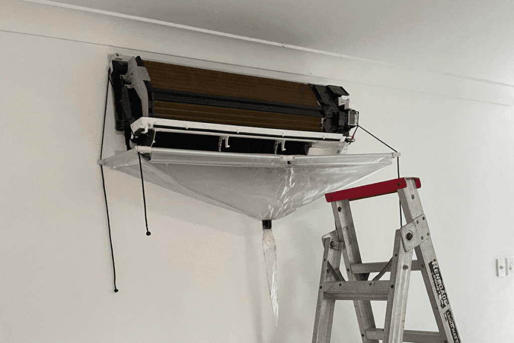Indoor aircon unit being prepared for hydroclean service with protective sheet, part of DEEPCHILL’s air conditioning cleaning process on the Gold Coast.