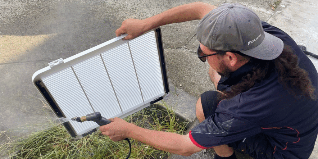 Technician performs preventative maintenance on an air conditioner that is not used, ensuring clean filters and efficient cooling for Gold Coast homes.