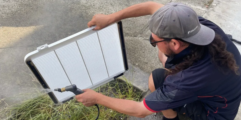 Technician performs preventative maintenance on an air conditioner that is not used, ensuring clean filters and efficient cooling for Gold Coast homes.