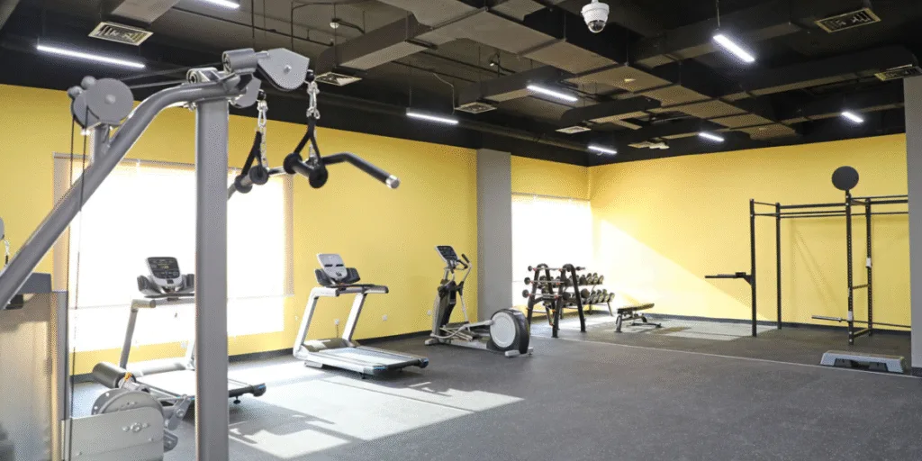 Modern fitness room with cardio and weight machines cooled by air conditioning in gyms, ensuring comfort and clean air with air conditioning Gold Coast service.
