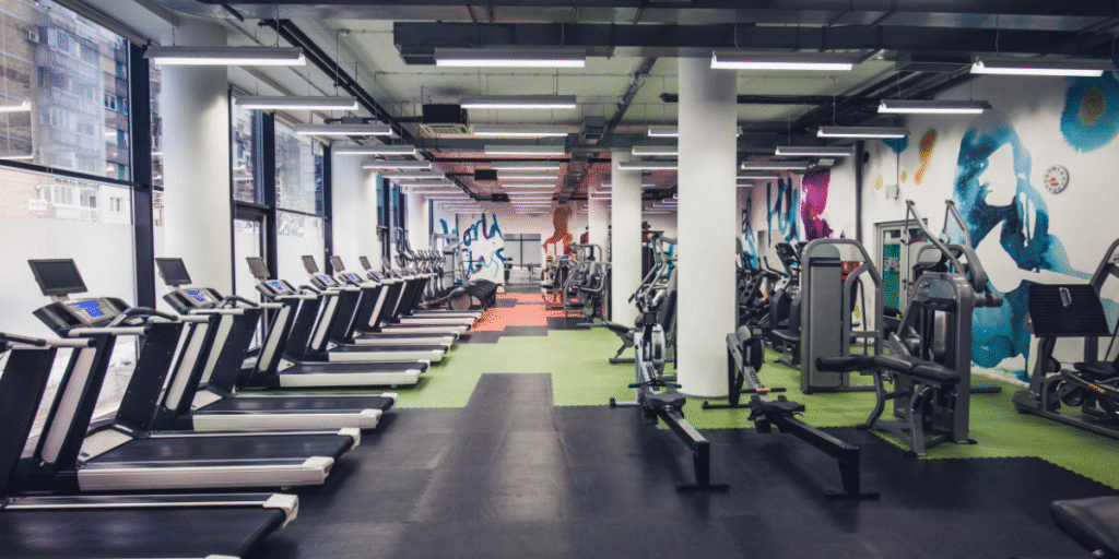 Modern fitness centre with treadmills and strength machines, highlighting the importance of air conditioning maintenance for gyms, including Hydro Clean services by air conditioning Gold Coast specialists.