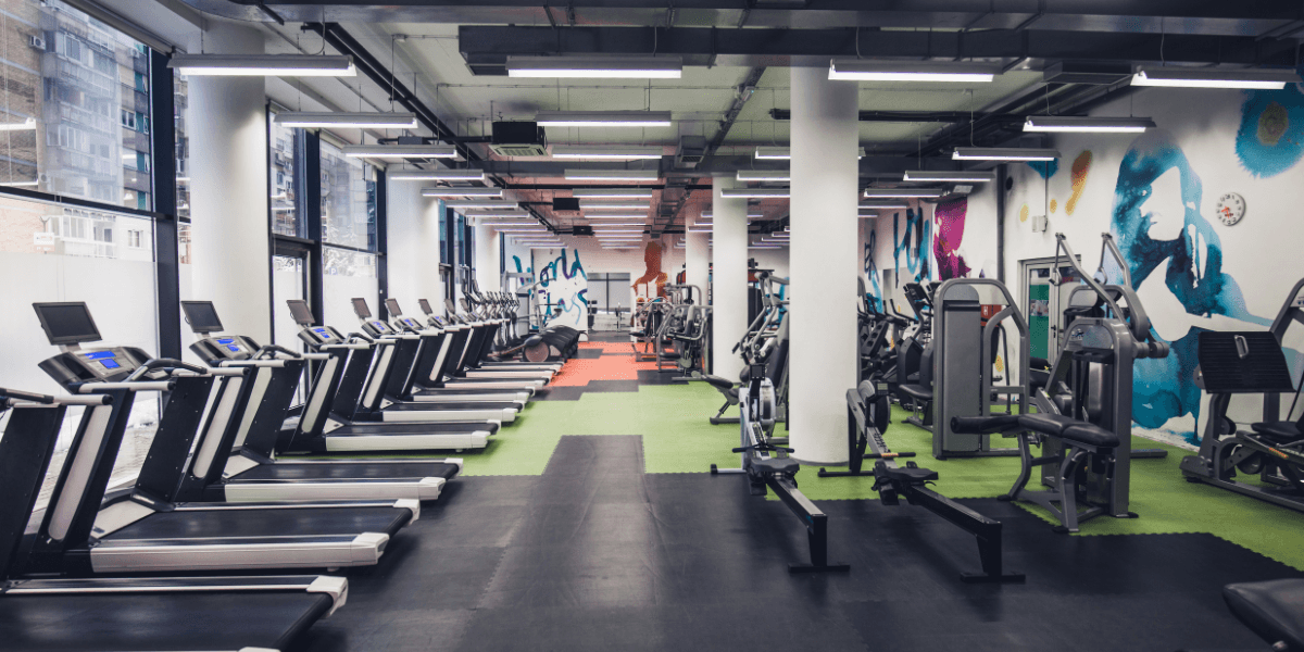 Modern fitness centre with treadmills and strength machines, highlighting the importance of air conditioning maintenance for gyms, including Hydro Clean services by air conditioning Gold Coast specialists.