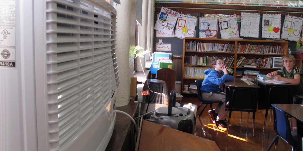 Classroom with students and window AC unit, demonstrating air conditioning regulations in schools and how air conditioning Gold Coast supports safe learning.