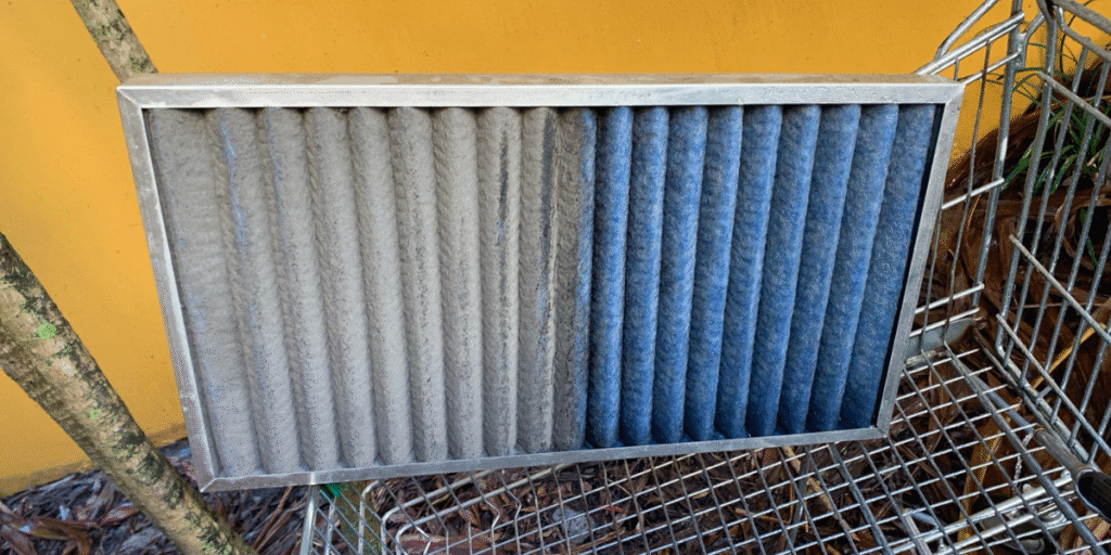 Side-by-side photo of a dirty and clean air conditioner filter, showing why aircon preventative maintenance is essential for healthy air and reliable air conditioning Gold Coast.