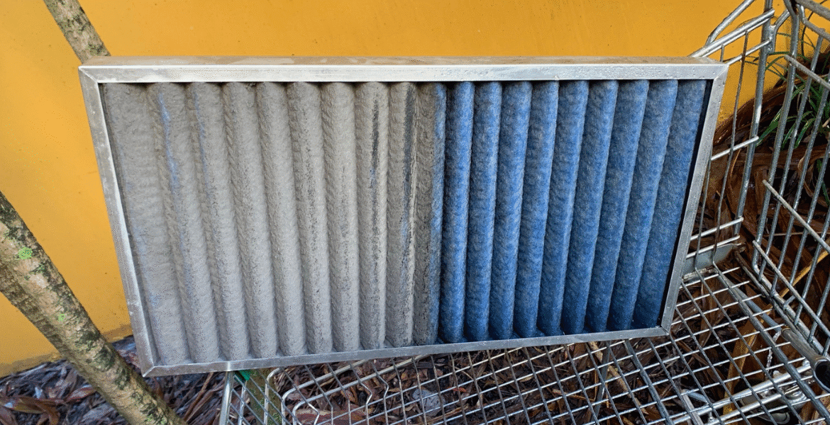 Side-by-side photo of a dirty and clean air conditioner filter, showing why aircon preventative maintenance is essential for healthy air and reliable air conditioning Gold Coast.