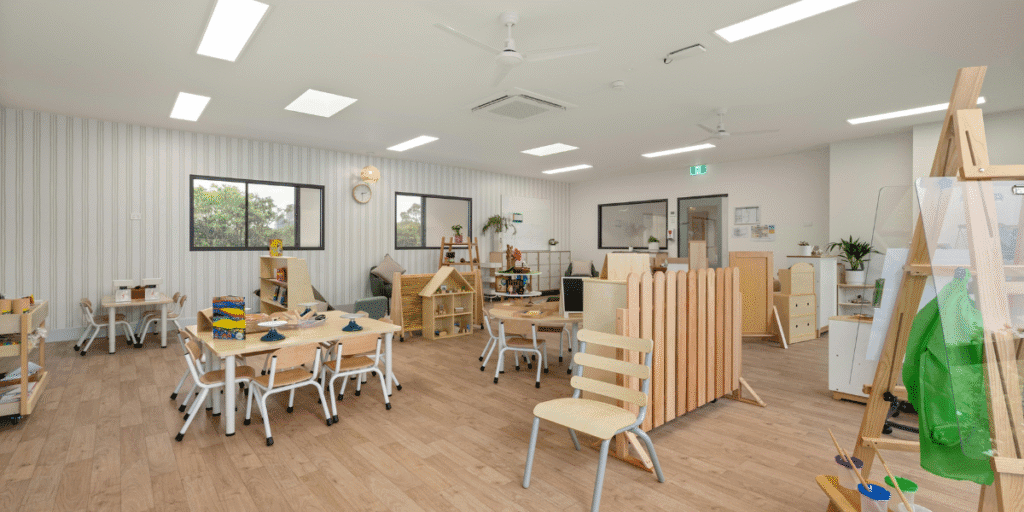 Preschool classroom with wooden tables and ceiling air conditioning, maintaining safe classroom temperature for children in Gold Coast.