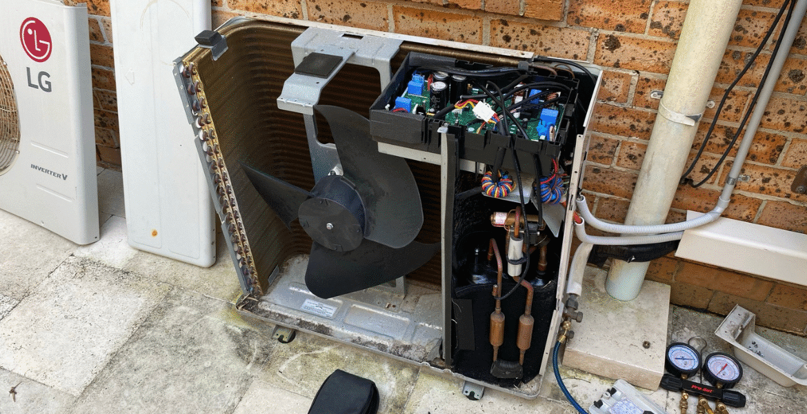 Technician performing AC check to do preventative maintenance on outdoor unit, ensuring reliable air conditioning Gold Coast service.