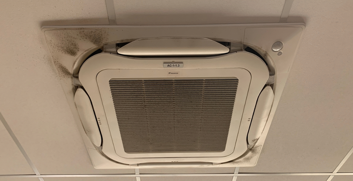 A ceiling cassette air conditioner with visible dirt and mold, demonstrating the health risks of using old air conditioner without preventative maintenance in air conditioning Gold Coast.