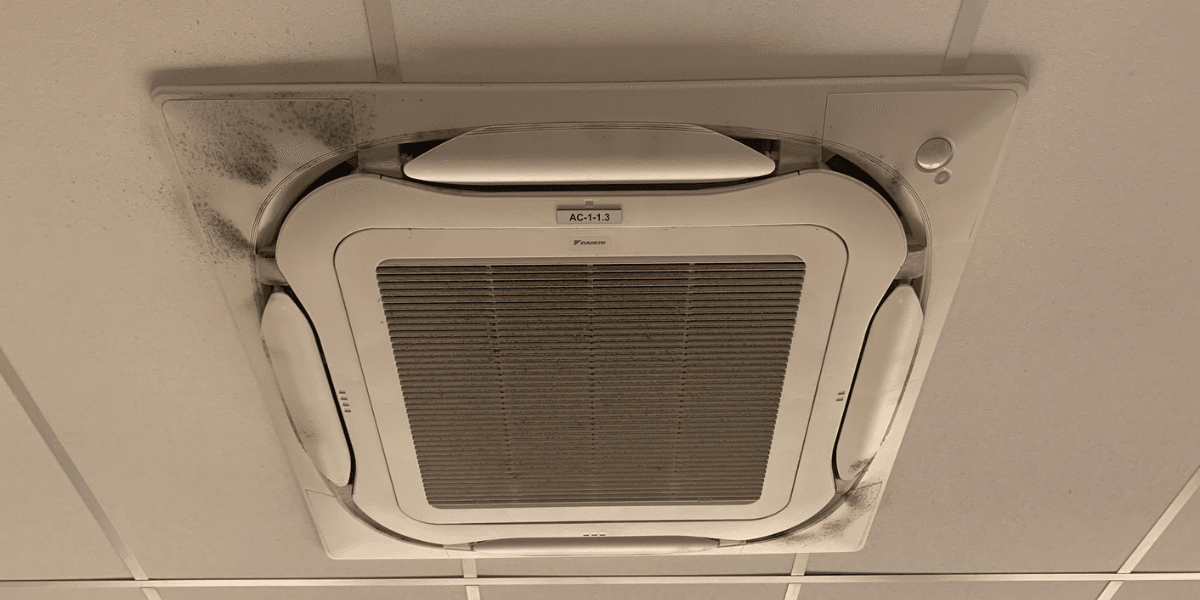 A ceiling cassette air conditioner with visible dirt and mold, demonstrating the health risks of using old air conditioner without preventative maintenance in air conditioning Gold Coast.