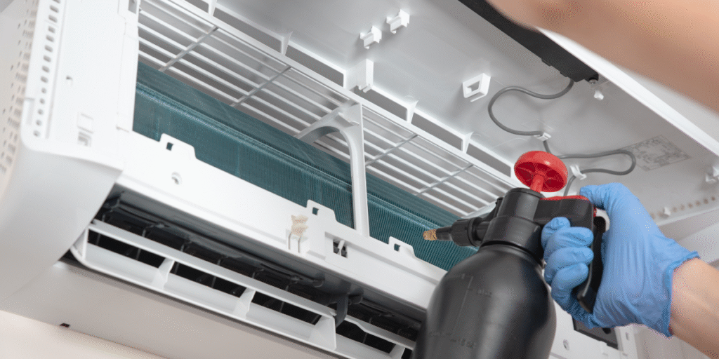 echnician cleaning the evaporator coil of a split air conditioner in Gold Coast to prevent dust buildup that could cause ac indoor fan not spinning issues, serviced by a professional air conditioning repair service Gold Coast.