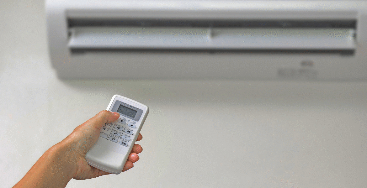 Person using a remote control to operate a wall-mounted air conditioner, checking airflow to confirm if ac indoor fan not spinning issue requires service from an air conditioning repair service Gold Coast.