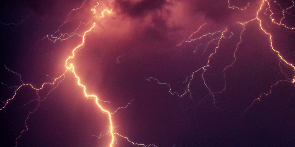 Close-up of powerful lightning strike flashing across the night sky during a thunderstorm — a common cause of power surges that can damage an air conditioner struck by lightning. This weather scene highlights storm risks for air conditioning Gold Coast homes.