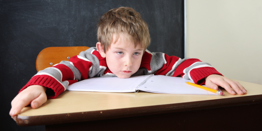 A tired student struggling to stay focused in class during a heatwave, highlighting the need for effective air conditioning Gold Coast and DEEPCHILL response in 24 hours.