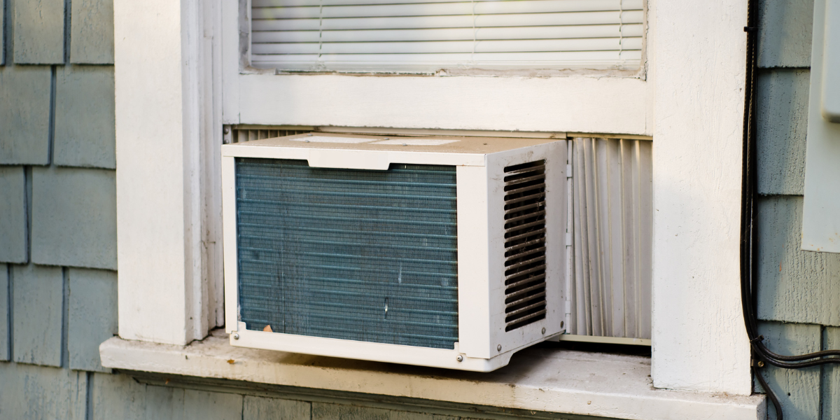 An old window air conditioner exposed to heat and rain, showing why homeowners should prevent air conditioner damage in severe weather with proper maintenance by air conditioning Gold Coast experts.