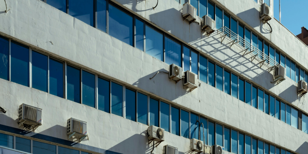 Multiple outdoor air conditioning units installed on a school building, highlighting the impact of system design and maintenance on school energy costs for air conditioning Gold Coast facilities.