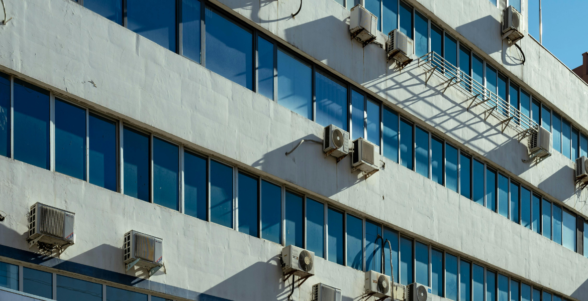 Multiple outdoor air conditioning units installed on a school building, highlighting the impact of system design and maintenance on school energy costs for air conditioning Gold Coast facilities.