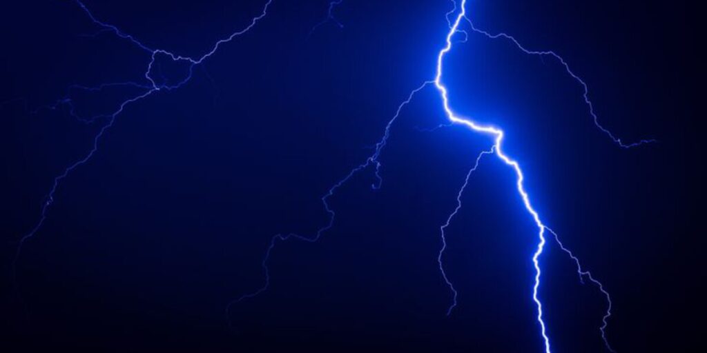 Close-up of lightning bolt during storm — illustrating power surge risks when people use air conditioner during thunderstorms, shared by air conditioning Gold Coast experts.