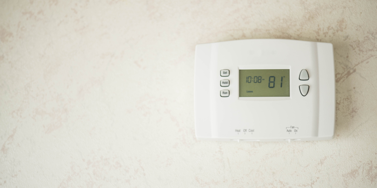 Close-up of a smart thermostat displaying 24°C, illustrating the recommended AC temperature during heatwave for Gold Coast homes. Air conditioning Gold Coast guidance.