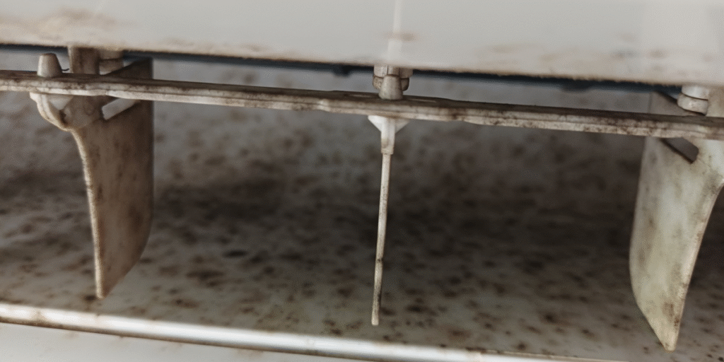 Mold in air conditioner visible on plastic louvers and internal casing, indicating moisture and hygiene problems often found in poorly maintained air conditioning Gold Coast units.