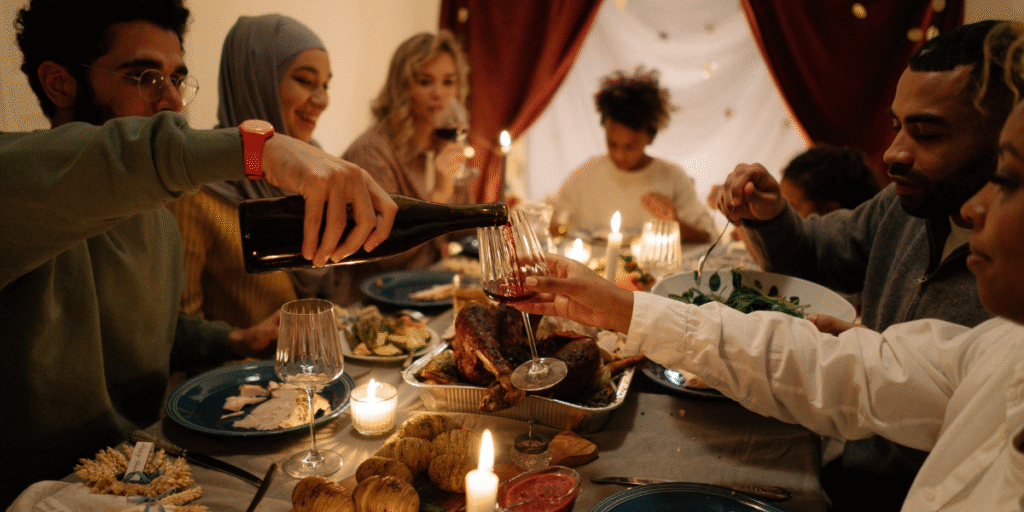 A group of people sharing a cozy Thanksgiving dinner with candles, roasted turkey, and warm lighting, capturing the seasonal atmosphere when Thanksgiving energy bills rising becomes a concern. The image reflects why families try to keep costs low and rely on smart climate control solutions such as air conditioning Gold Coast maintenance.